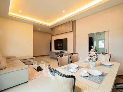 Elegant living room with modern decor and dining area, featuring ambient lighting and stylish furniture.