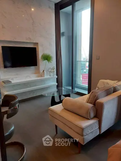 Modern living room with sleek furniture and large window offering natural light.