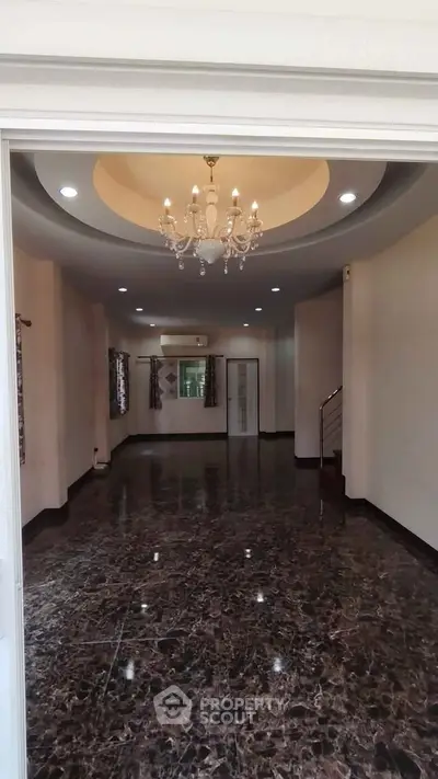 Spacious living room with elegant chandelier and marble flooring