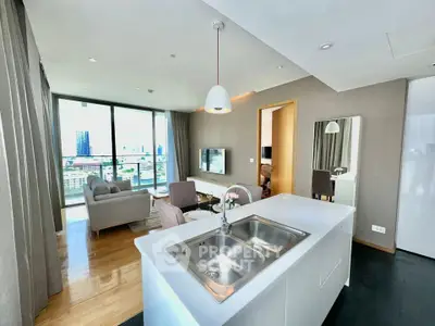 Modern open-plan living room with city view, featuring sleek kitchen island and cozy seating area.