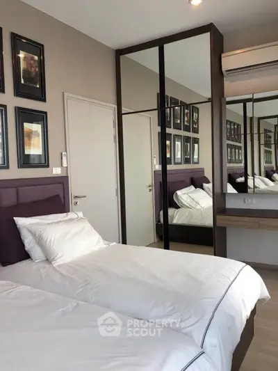 Modern bedroom with twin beds, mirrored wardrobe, and stylish decor