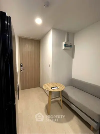 Cozy modern living area with sleek furniture and wooden accents in a compact apartment.
