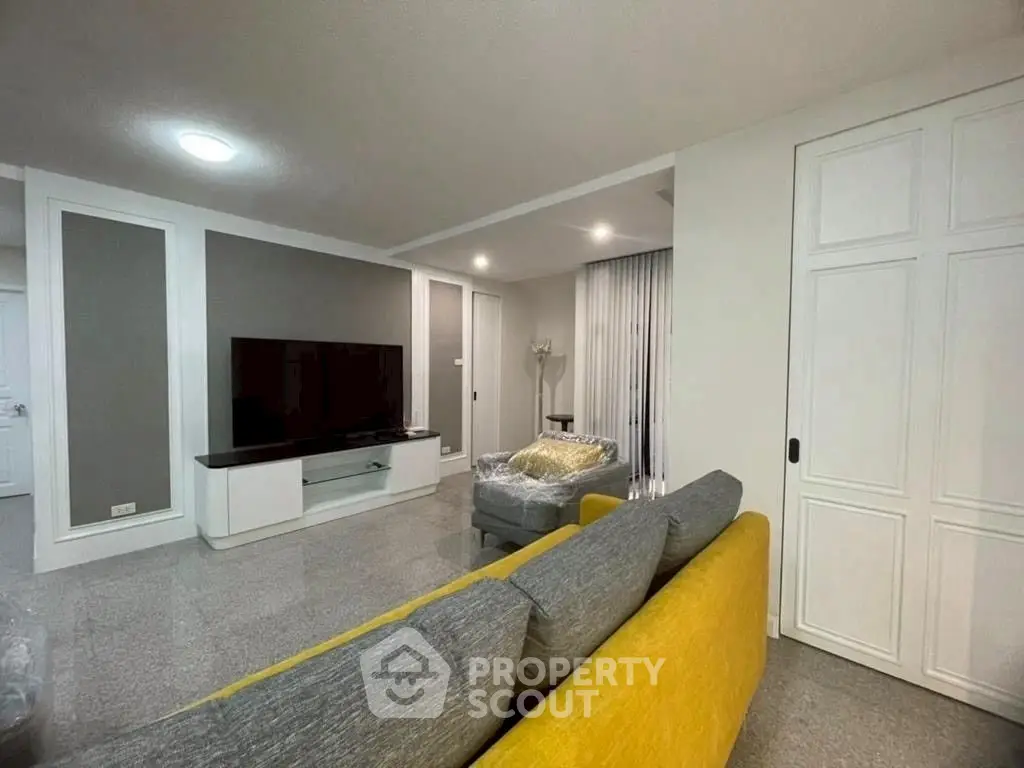 Spacious modern living room with stylish decor and large TV setup