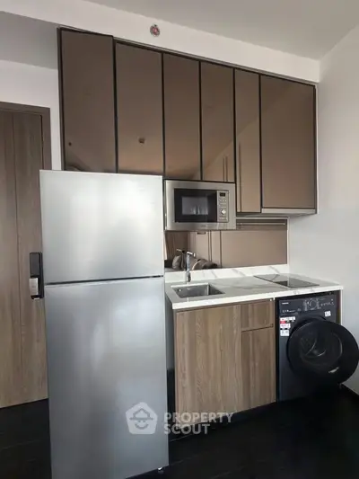 Modern compact kitchen with stainless steel appliances and sleek cabinetry