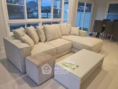 Spacious living room with modern sectional sofa and sleek coffee table, perfect for relaxation and entertaining.
