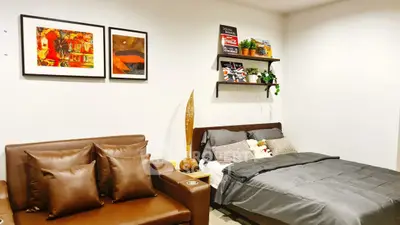 Modern bedroom with stylish decor and cozy seating area, perfect for relaxation and comfort.