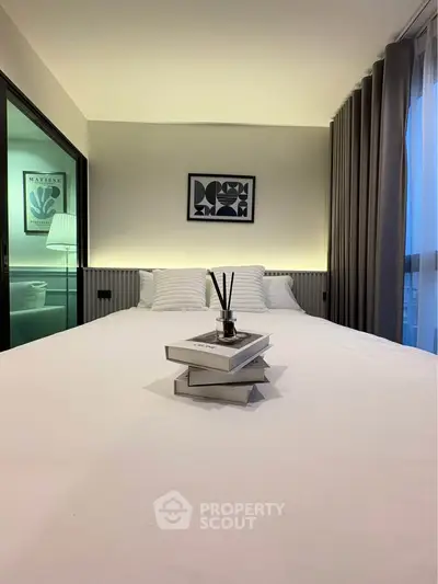 Modern bedroom with stylish decor and large window offering natural light.