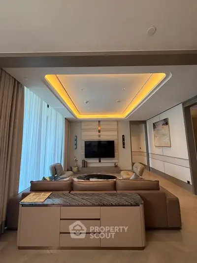 Luxurious living room with modern decor and ambient lighting, featuring a large TV and elegant furniture.
