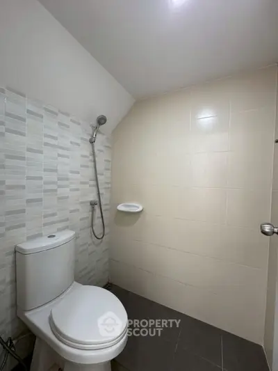 Modern minimalist bathroom with shower and toilet in neutral tones