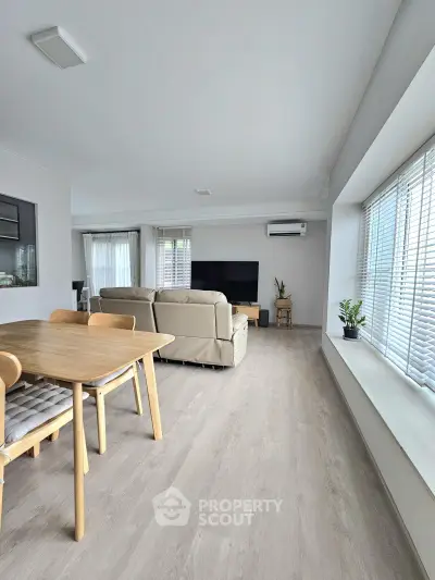 Spacious modern living room with sleek furniture and large windows for natural light.