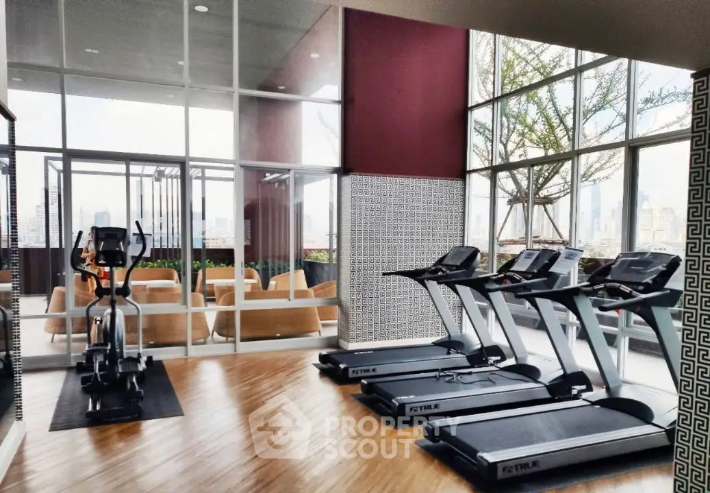 Modern gym with treadmills and city view in luxury apartment complex.