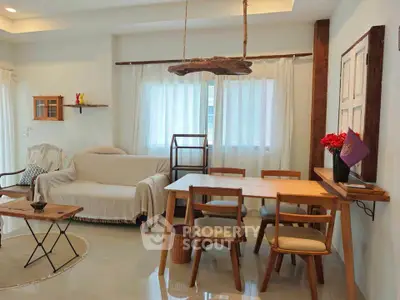 Charming living room with cozy dining area and natural light, featuring rustic wooden furniture and modern decor.