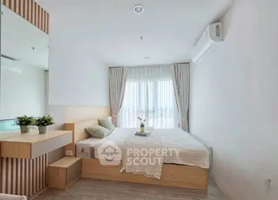 Modern bedroom with large window and stylish decor in a contemporary apartment.