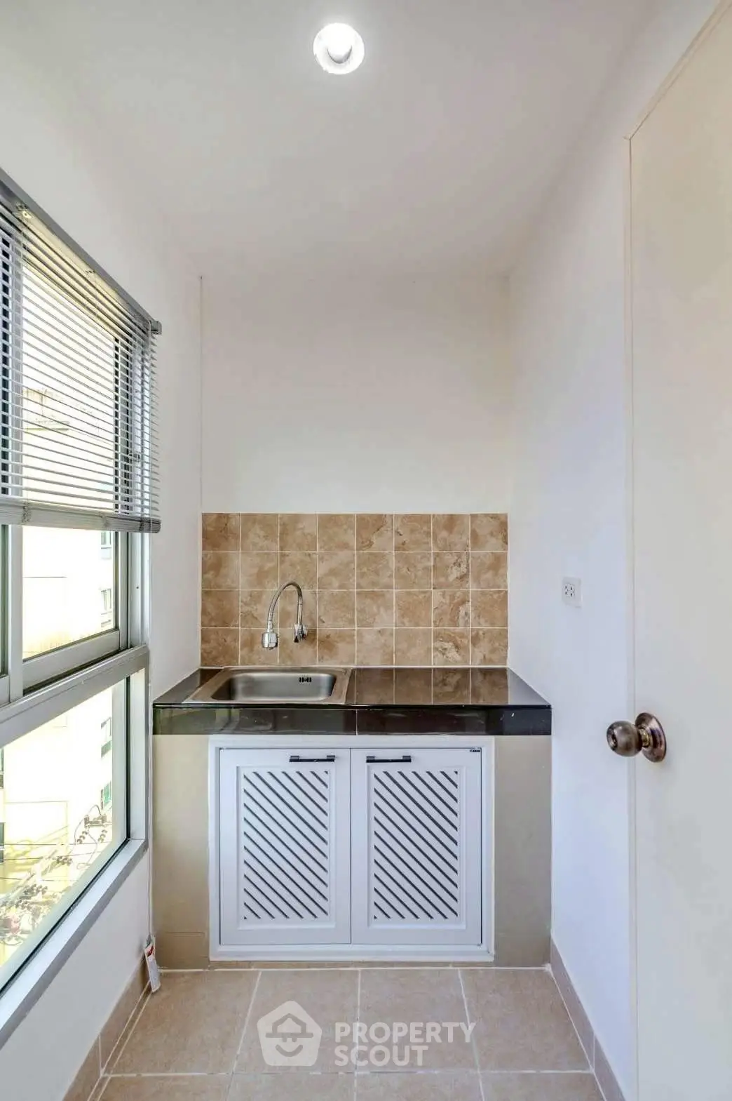 Compact kitchen area with modern sink and tiled backsplash