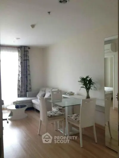 Modern living room with elegant dining area and cozy seating, featuring stylish decor and natural light.