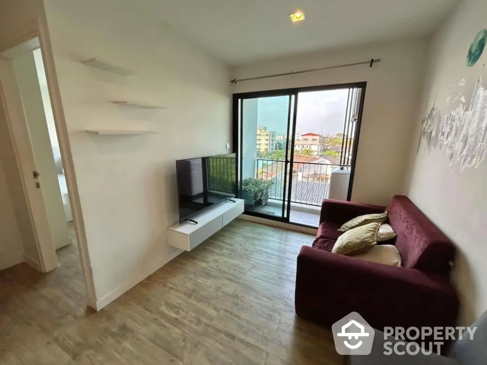 Modern living room with large window and city view, featuring a cozy sofa and wall-mounted TV.