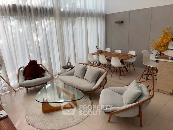 Spacious modern living room with elegant furniture and large windows for natural light.