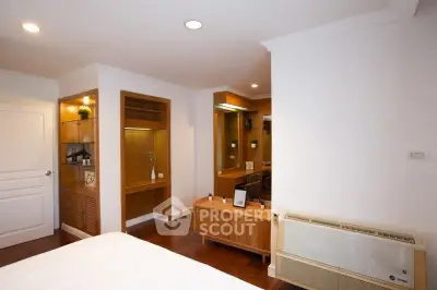 Spacious bedroom with elegant wooden furniture and built-in storage solutions.