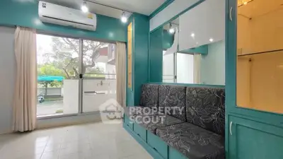 Charming living room with built-in seating and large window overlooking greenery.
