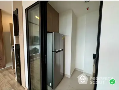 Modern kitchen with sleek refrigerator and glass door entry