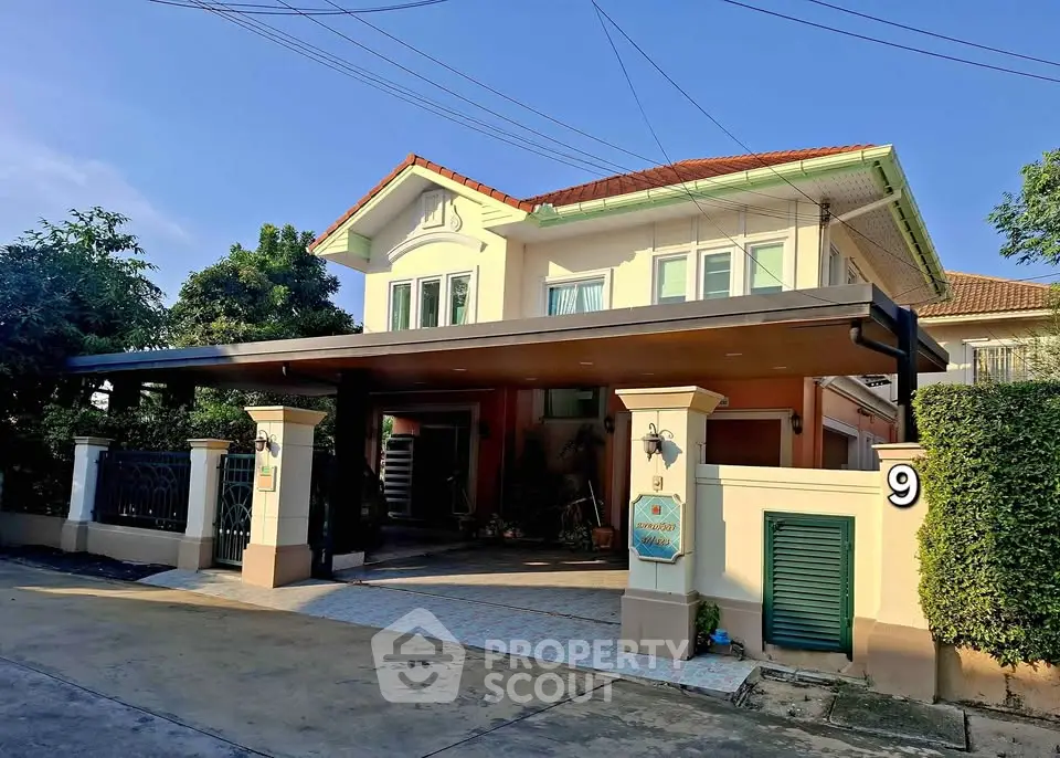 Charming two-story house with spacious driveway and lush greenery, perfect for family living.