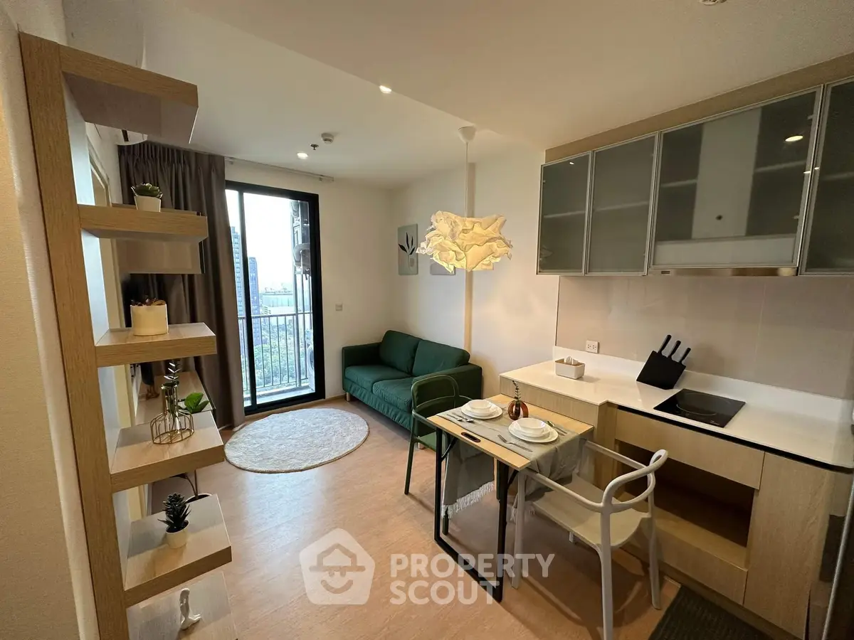 Modern living room with open kitchen, stylish decor, and balcony view in a cozy apartment.