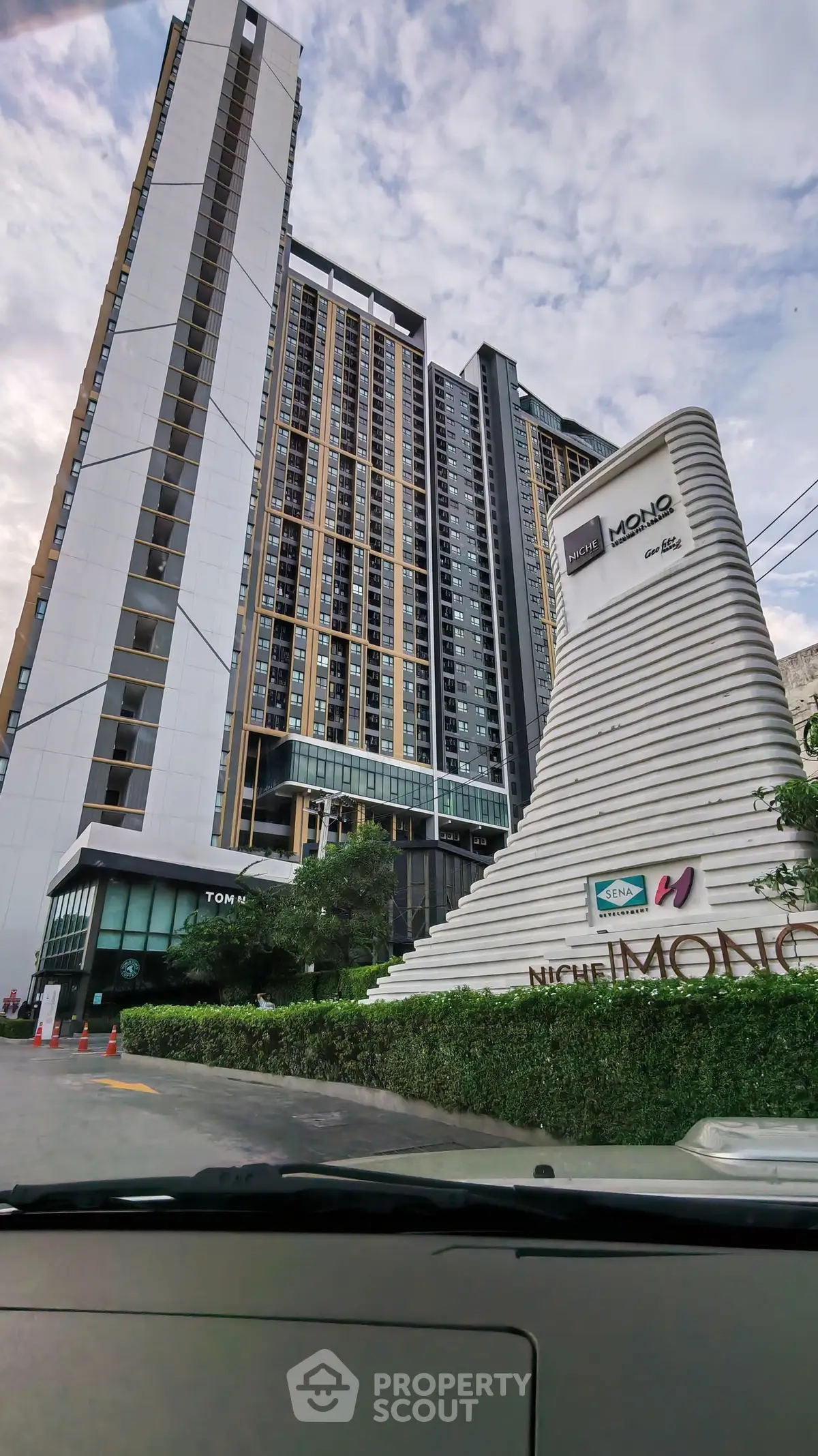 Modern high-rise condominium with sleek architectural design and lush landscaping.