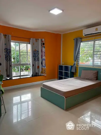 Spacious bedroom with large windows and vibrant orange walls