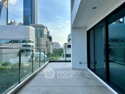 Spacious urban balcony with stunning cityscape views and modern glass railing.