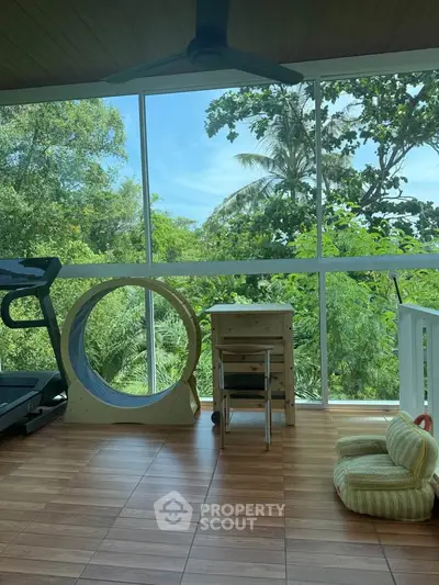 Spacious balcony with exercise equipment and lush green view, perfect for relaxation and fitness.