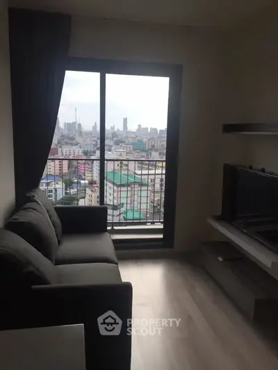 Modern living room with city view from balcony, featuring sleek furniture and large windows.