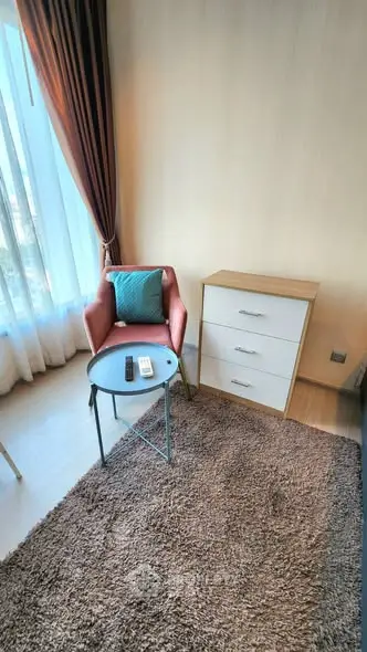 Cozy corner with modern armchair and stylish dresser in bright apartment.