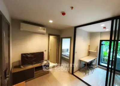 Modern apartment interior with air conditioning, sliding glass doors, and a cozy study area.