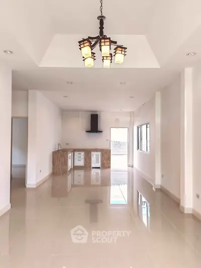 Spacious open-plan living room with modern kitchen and elegant lighting