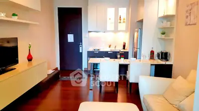 Modern living room with open kitchen, stylish decor, and cozy seating area in a contemporary apartment.