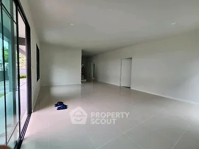 Spacious empty living room with large windows and tiled floor, perfect for customization.