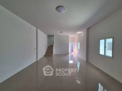 Spacious modern interior with glossy tiled floors and staircase