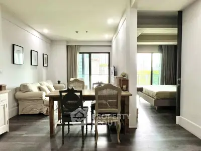 Spacious open-plan living room with dining area and bedroom in modern apartment.