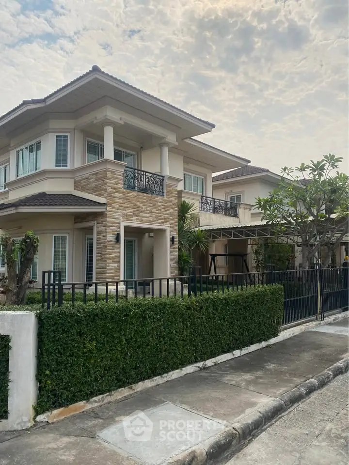 Elegant two-story house with modern architecture and lush greenery in a serene neighborhood.
