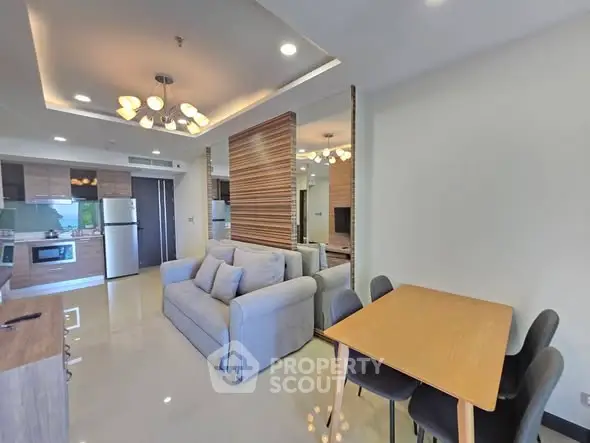 Modern open-plan living room with stylish kitchen and dining area in a contemporary apartment.