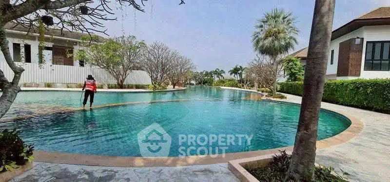 Luxurious residential pool area with lush greenery and modern architecture, perfect for relaxation and leisure.