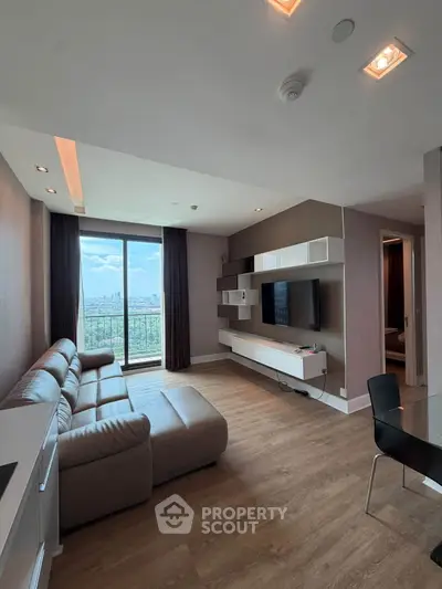 Modern living room with city view, featuring sleek furniture and stylish decor in a high-rise apartment.