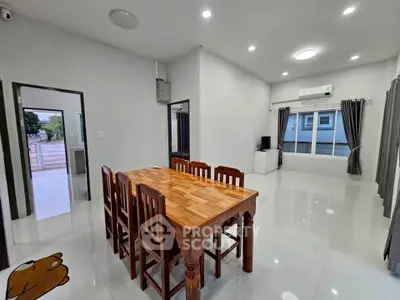 Spacious modern dining area with wooden table and chairs, bright lighting, and large window view.