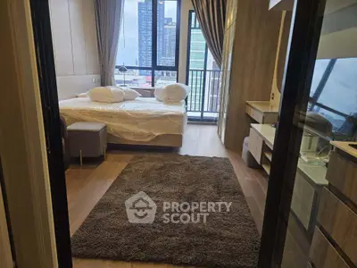 Modern bedroom with city view, featuring cozy decor and large windows for natural light.