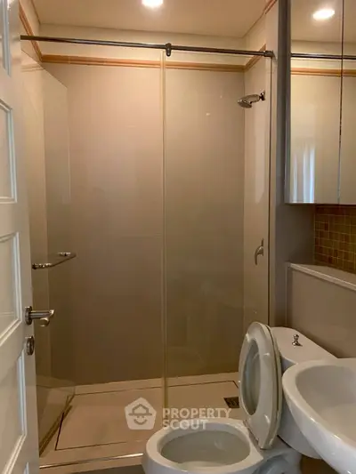 Modern bathroom with glass shower enclosure and sleek fixtures