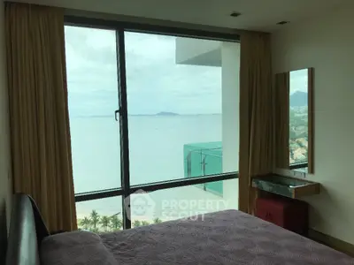 Luxurious bedroom with stunning ocean view and floor-to-ceiling windows in modern apartment.