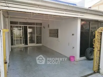 Spacious covered patio with sliding glass doors and tiled flooring, ideal for outdoor gatherings.