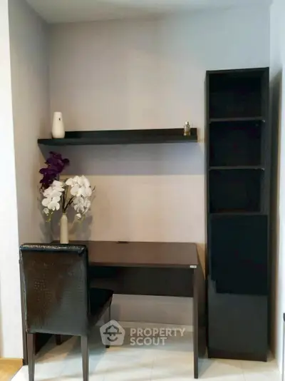 Modern study nook with sleek desk, chair, and decorative shelf in a cozy corner.