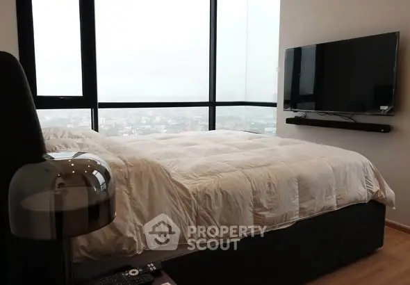 Luxurious bedroom with panoramic city view and modern amenities.