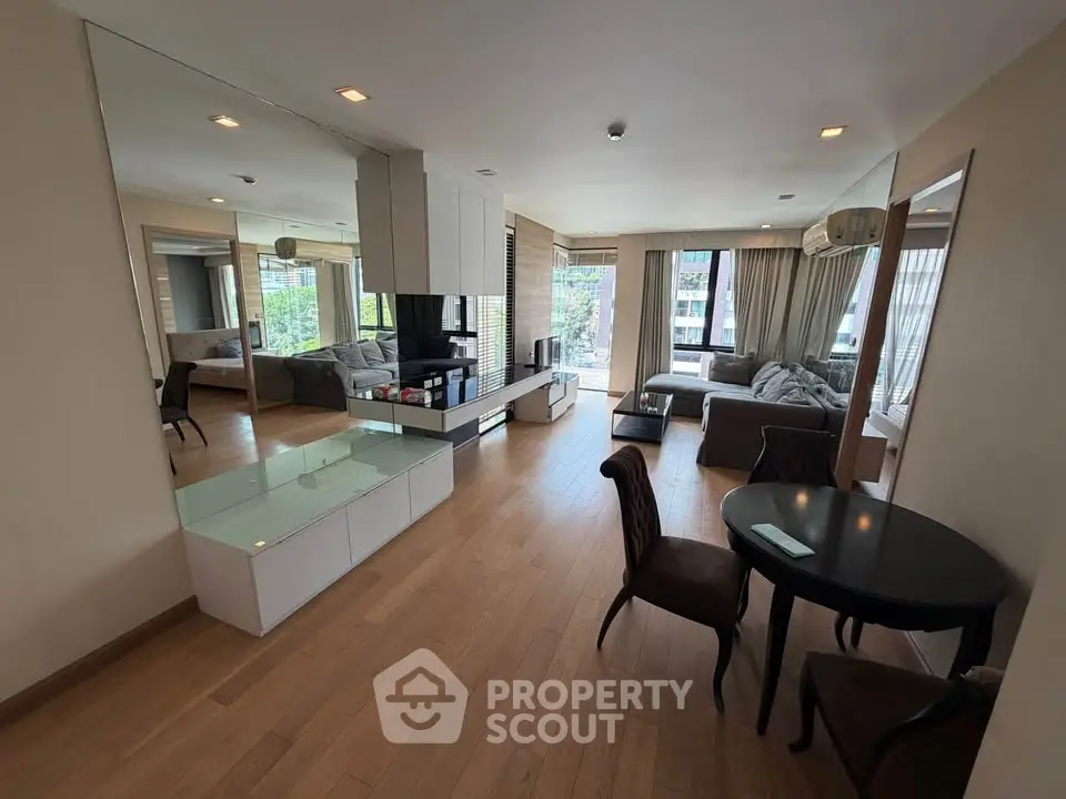 Spacious modern living room with elegant furniture and large windows offering natural light.